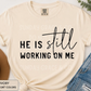 He Is Still Working On Me | Comfort Colors® Tee